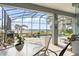 Covered patio with outdoor seating overlooking screened-in pool and lake at 720 Basin Dr, Kissimmee, FL 34744