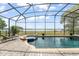 A screened in pool with a hot tub and an open view of the water nearby at 720 Basin Dr, Kissimmee, FL 34744