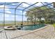 Screened in in-ground pool and attached spa offer clear views of the nearby waterway at 720 Basin Dr, Kissimmee, FL 34744