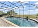 A screened in pool with a jacuzzi and a view of the water at 720 Basin Dr, Kissimmee, FL 34744