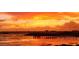 Stunning view of a sunset over the lake, featuring silhouettes of a pier and distant buildings at 720 Basin Dr, Kissimmee, FL 34744