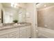 A bright bathroom boasts a double sink vanity with granite countertops and a shower-tub combo at 977 Paradise Dr, Davenport, FL 33897