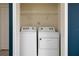 The laundry room features a side-by-side washer and dryer and a wire shelf above at 977 Paradise Dr, Davenport, FL 33897