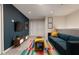 Modern living room featuring a blue sofa, colorful rug, and stylish decor at 977 Paradise Dr, Davenport, FL 33897