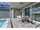 An outdoor dining area by the screened-in pool is perfect for relaxing and entertaining at 977 Paradise Dr, Davenport, FL 33897
