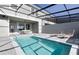 This screened-in pool features sun loungers and an outdoor dining area, perfect for relaxing at 977 Paradise Dr, Davenport, FL 33897