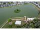 An aerial perspective showcases a lake with an island, accompanied by a playground, beach, and surrounding residences at 979 Park Terrace Cir, Kissimmee, FL 34746