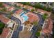 A vibrant aerial view showcasing a community pool with blue umbrellas and surrounding yellow and red-roofed buildings at 979 Park Terrace Cir, Kissimmee, FL 34746