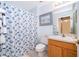 Well-lit bathroom featuring seashell-themed decor, a vanity with mirror, and a shower with seashell shower curtain at 979 Park Terrace Cir, Kissimmee, FL 34746