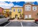 Charming, colorful townhome exterior with lush landscaping and a well-maintained front yard in a sunny neighborhood at 979 Park Terrace Cir, Kissimmee, FL 34746