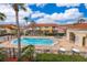 Community pool area with lounge chairs, mature trees, and nearby residential buildings on a sunny day at 979 Park Terrace Cir, Kissimmee, FL 34746