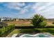Backyard features pool with safety fence, with view of neighborhood at 9870 Summerlake Groves St, Winter Garden, FL 34787