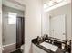 Bathroom featuring a vanity with a black countertop, shower-tub combo, and grey accent rugs at 9870 Summerlake Groves St, Winter Garden, FL 34787