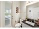 Well-lit powder room featuring a black granite vanity top and access to an outdoor living space at 9870 Summerlake Groves St, Winter Garden, FL 34787