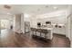 Spacious kitchen featuring gleaming wood floors, a center island with bar seating, and modern appliances at 9870 Summerlake Groves St, Winter Garden, FL 34787