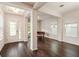 Bright living room featuring gleaming wood floors, columns, large windows, and a glass door at 9870 Summerlake Groves St, Winter Garden, FL 34787