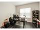 Well-lit home office with a dark wood floor, black desk and large window at 9870 Summerlake Groves St, Winter Garden, FL 34787