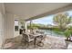 Charming covered patio with a dining set overlooking the pool and lush landscaping at 9870 Summerlake Groves St, Winter Garden, FL 34787
