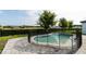 Backyard pool features -safety fence, brick pavers, green space, and mature tree at 9870 Summerlake Groves St, Winter Garden, FL 34787