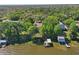 Aerial view of a home surrounded by lush greenery, with a dock and boathouse on the waterfront at 9900 W Lake Marion Rd, Haines City, FL 33844