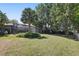 Backyard featuring mature trees, landscaping and screened in patio overlooking the water at 9900 W Lake Marion Rd, Haines City, FL 33844