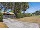 Home featuring a well-maintained front yard, a gated driveway, mature landscaping, and curb appeal at 9900 W Lake Marion Rd, Haines City, FL 33844