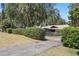 Home featuring a well-maintained front yard, a gated driveway, mature landscaping, and curb appeal at 9900 W Lake Marion Rd, Haines City, FL 33844