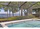 A covered pool with a view of the water provides a refreshing escape and a chance to enjoy the surrounding nature at 9900 W Lake Marion Rd, Haines City, FL 33844