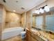 Bathroom featuring a bathtub, granite countertop, and tiled walls at 101 S Eola Dr # 1209, Orlando, FL 32801