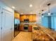 Galley kitchen featuring tan cabinets, stainless steel appliances and tan granite countertops at 101 S Eola Dr # 1209, Orlando, FL 32801