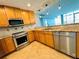 Galley kitchen featuring tan cabinets, stainless steel appliances and tan granite countertops at 101 S Eola Dr # 1209, Orlando, FL 32801