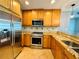 Galley kitchen featuring tan cabinets, stainless steel appliances and tan granite countertops at 101 S Eola Dr # 1209, Orlando, FL 32801