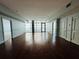 Bright, empty living room featuring beautiful hardwood floors and large windows that offer city views at 101 S Eola Dr # 1209, Orlando, FL 32801