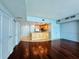 Open concept living space with hardwood floors, kitchen with wooden cabinets, and light blue walls at 101 S Eola Dr # 1209, Orlando, FL 32801
