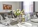 Staged dining room setting featuring silverware, glassware, and decorative flower centerpiece at 103 Mason Park Dr, Daytona Beach, FL 32117