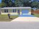 Charming one-story home featuring a yellow exterior, an attached garage, and a well-manicured front yard at 103 Mason Park Dr, Daytona Beach, FL 32117