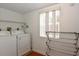 Laundry room with washer, dryer, rack, and a window for natural light at 103 Mason Park Dr, Daytona Beach, FL 32117