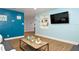 Bright living room with wood floors, blue walls, a mounted flat screen television and coastal decor at 103 Mason Park Dr, Daytona Beach, FL 32117