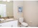Well-lit bathroom featuring granite countertops, white cabinets and framed artwork at 106 Oceans Cir, Daytona Beach, FL 32118