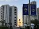 Exterior view of high-rise buildings with 'Life is better here' banners, palm trees, and a clear sky at 106 Oceans Cir, Daytona Beach, FL 32118