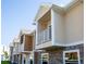 Row of modern townhomes with stone accents and private balconies under a blue sky at 106 Oceans Cir, Daytona Beach, FL 32118