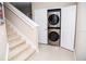 Convenient laundry room located near the stairs, featuring modern, stacked washer and dryer units at 106 Oceans Cir, Daytona Beach, FL 32118