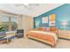 Modern bedroom with a turquoise accent wall, contemporary art, and two chairs at 106 Oceans Cir, Daytona Beach, FL 32118