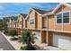 Row of tan two-story townhomes with white trim, garages, and small, newly planted trees at 106 Oceans Cir, Daytona Beach, FL 32118