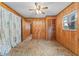 Bedroom featuring wood paneling, ceiling fan, and ample natural light at 10900 Tangora St, Orlando, FL 32825