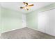 Bedroom with light green walls, ceiling fan, and a large closet at 10900 Tangora St, Orlando, FL 32825