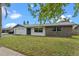 Inviting single-story home featuring a well-manicured lawn and eye-catching stone accents at 10900 Tangora St, Orlando, FL 32825