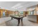 Spacious game room featuring a stylish bar, wood paneling and a classic pool table at 10900 Tangora St, Orlando, FL 32825