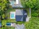 Aerial view of a house with a dark metal roof, swimming pool, well-manicured lawn and mature trees at 1136 W Harvard St, Orlando, FL 32804