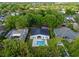 An aerial view of a house with a pool, pergola, landscaped yard, and a dark gray metal roof at 1136 W Harvard St, Orlando, FL 32804